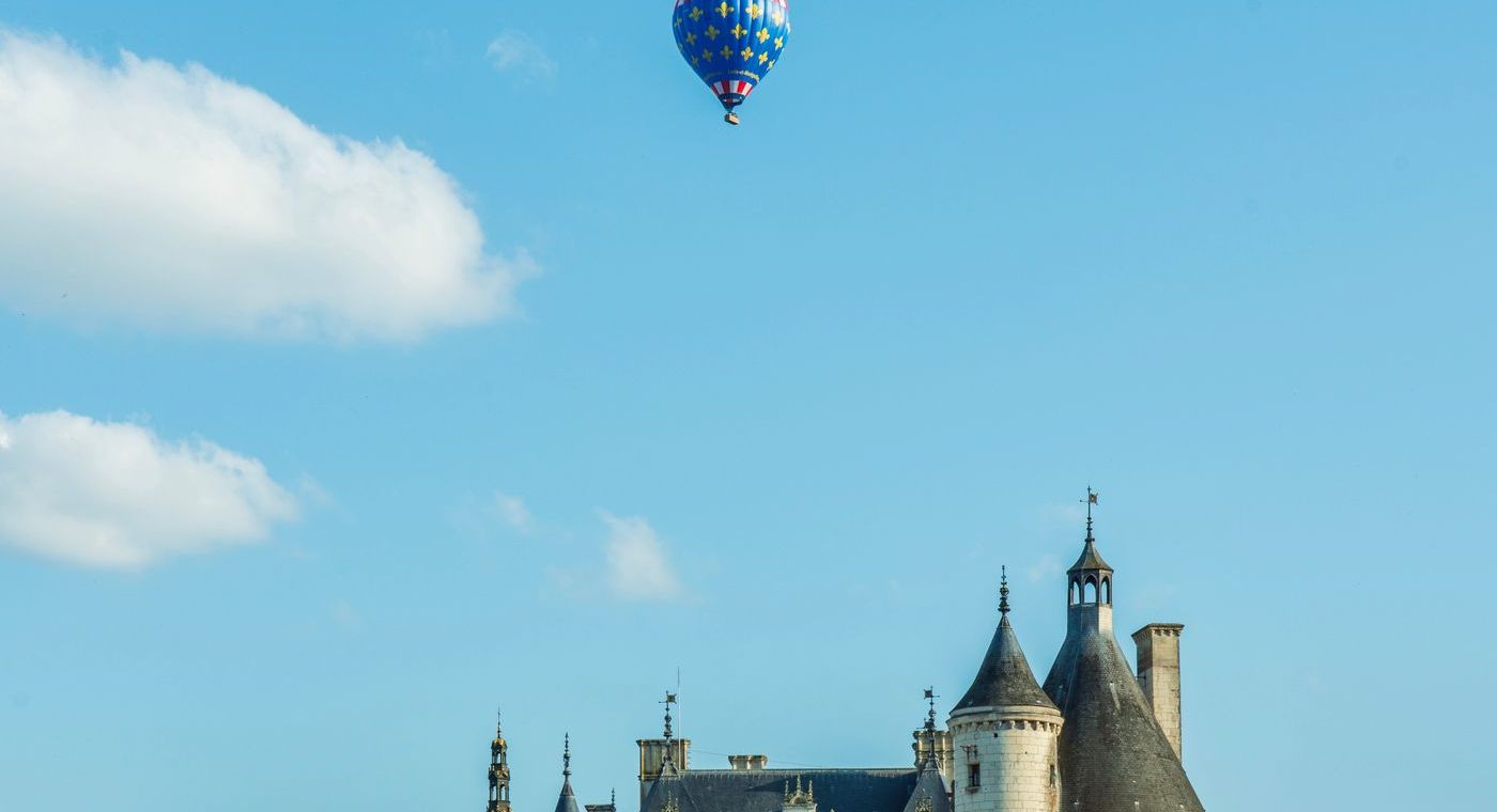 Une montgolfière aux fleurs de lys au-dessus des tourelles du château de Chenonceau
